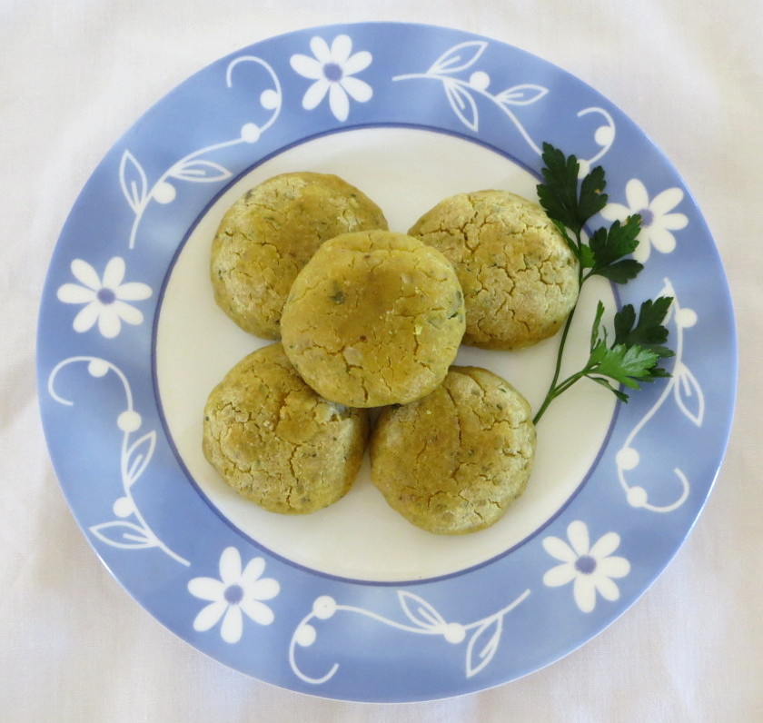 Dish with chia and okara cakes and bunch of parsley